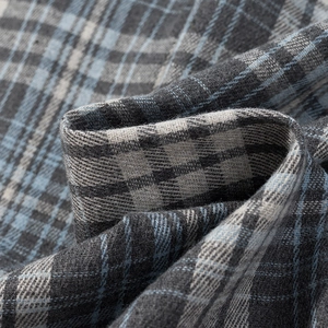 Vue macro de la texture du tissu en flanelle à carreaux gris et bleu brossé doux