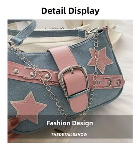 Close-up of blue denim baguette bag featuring pink leather stars and silver chain detail