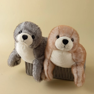 Peluche di foca realistici in grigio e marrone in un accogliente cesto intrecciato