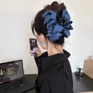 Detailed back view of a large blue denim bow hair claw clip for a full hair look