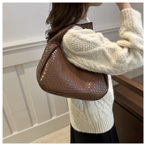 Close-up of brown woven leather texture on a stylish underarm bag for women