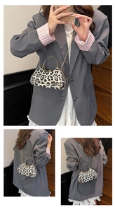 Detail of leopard print evening clutch with gold ring handle and metal chain strap
