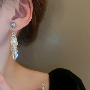Détail de boucles d'oreilles à pampilles en argent avec perle grise sur un mannequin