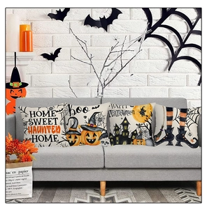 Set of four Halloween pillow covers featuring pumpkin and castle prints on a gray sofa