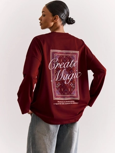 Nahaufnahme des Vintage-Musters und Create Magic Text auf der Rückseite des burgunderfarbenen Shirts