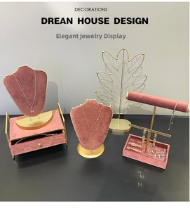 Detailed jewelry display set featuring gold metal racks and vintage pink velvet cushions