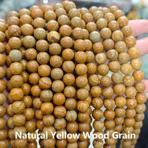 Detailed close-up showing natural yellow wood grain pattern on round beaded stone accessories
