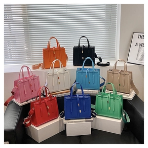 Detail showing various colors of stylish rectangular PU leather handbags with wide straps