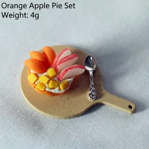 Macro detail of dollhouse fruit pie with mango and apple on a tiny wooden tray