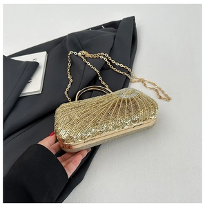 Detail of gold sequin evening clutch bag with ring handle and elegant chain strap