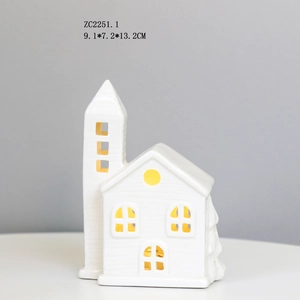 Detail of white ceramic house LED lamp with hollow windows and warm glow light