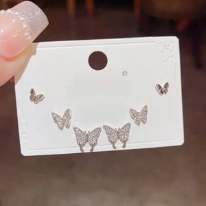 Macro shot of silver butterfly stud earrings set with zircon stones on display card