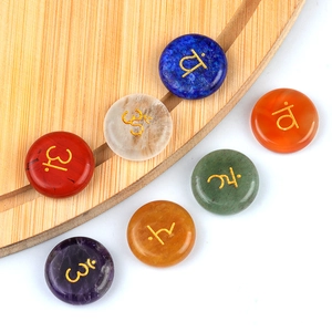 Set of seven natural chakra stones with gold engraved yoga symbols for healing