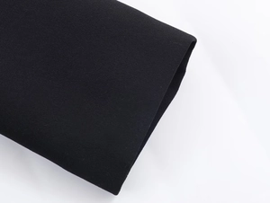 Detailed close-up of high-quality black crepe fabric texture on the dress sleeve cuff
