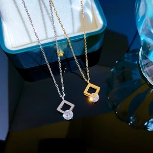 Detail of square zircon pendant necklaces in gold and silver finish on a jewelry box
