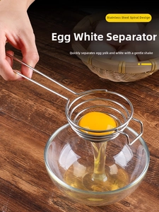 Close-up of stainless steel spiral egg white separator on a dark wooden table background