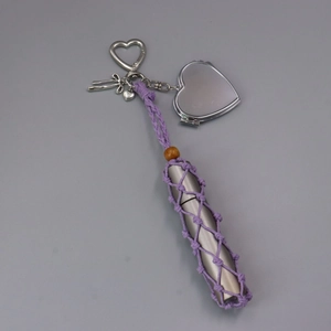Dettaglio portachiavi a rete viola con specchio a cuore e ciondolo in metallo argento