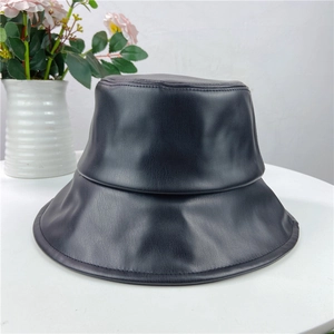 Close-up of black PU leather bucket hat showing detailed lychee texture and fine stitching