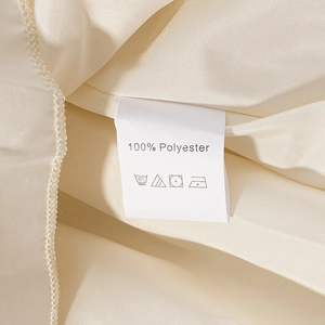 Detailed view of clothing care label showing 100% polyester material and washing icons