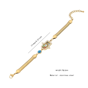 Détail du bracelet Hamsa en acier doré avec perles œil bleu et pendentif en zircon