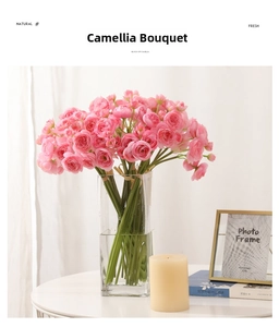 Pink camellia artificial flowers in a glass vase on a stylish table with decor