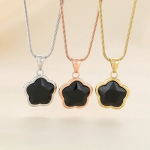 Detailed view of three four-leaf clover necklaces in silver, rose gold, and gold plating