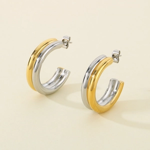 Detailed view of C-shaped mixed metal earrings with gold and silver polished finish