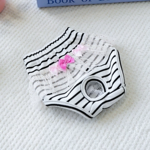 Close-up of black and white striped dog diaper with pink bows and white lace trim