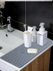 Macro detail of a gray silicone drainage mat with non-slip ridges on a modern sink counter