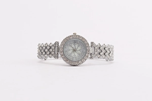 Close-up of sparkling floral silver watch with diamond-encrusted bracelet and Roman numerals