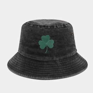 Close-up of green shamrock embroidery on vintage washed black denim bucket hat