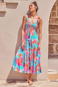 Detail of tiered floral maxi dress with bow tie shoulder straps and vibrant abstract prints