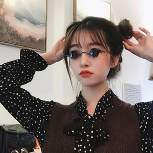 Retro small round steampunk sunglasses with black lenses and dark metal frame on a model