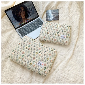 Close-up of floral quilted laptop sleeve showing soft fabric texture and fabric label