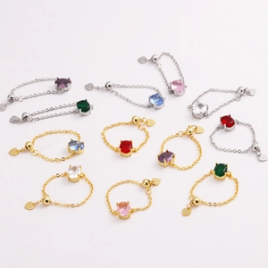 Gold and silver chain rings with oval colorful zircons and a small heart pendant charm