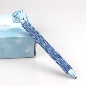 Macro shot of luxury ballpoint pen with blue rhinestones and large top crystal