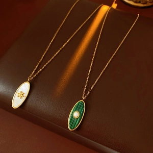 Detailed view of vintage gold necklaces with oval malachite and mother of pearl pendants