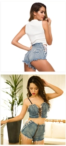 Dettaglio di pantaloncini di jeans blu con lacci laterali e orlo sfrangiato su una modella