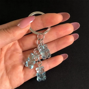 Detail of three blue translucent resin bear charms on a metallic keychain link