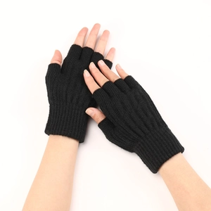 Close-up of black cable knit fingerless gloves showing texture and half-finger design