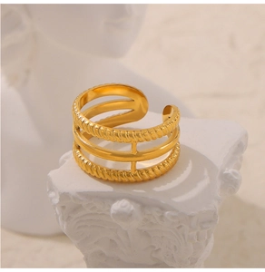 Detail eines dreischichtigen goldenen Rings mit Seilstruktur auf einem Steinsockel
