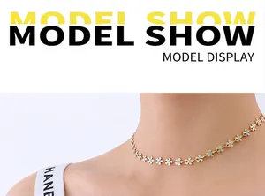 Detail of a gold-tone necklace featuring delicate light blue enamel flower pendants