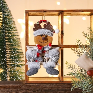 Plush Christmas reindeer ornament with red scarf and boots on a festive wooden background
