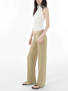 Detail view of khaki wide-leg trousers with elegant drape and slim sleeveless white top