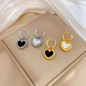 Detail of silver and gold heart hoop earrings with black and white inlay on satin