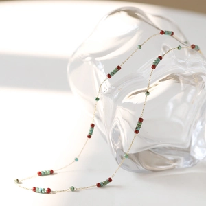 Detail of vintage style necklace with red and turquoise beads on a golden chain