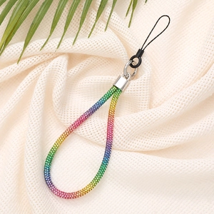 Close-up of rainbow rhinestone wrist strap with silver clasp on a textured white fabric