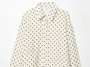 Macro detail of retro polka dot lapel shirt showing size S tag and fabric texture