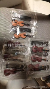 Detailed view of mini violin keychains in brown and dark red with standard metal rings