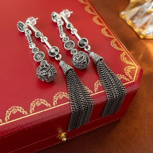 Vintage long tassel earrings with grey beaded spheres on a red jewelry box background